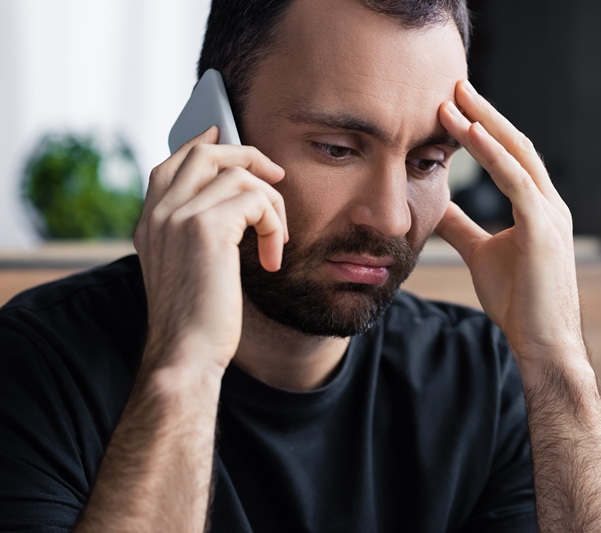 A man who is concerned while on the phone with homeowners insurance